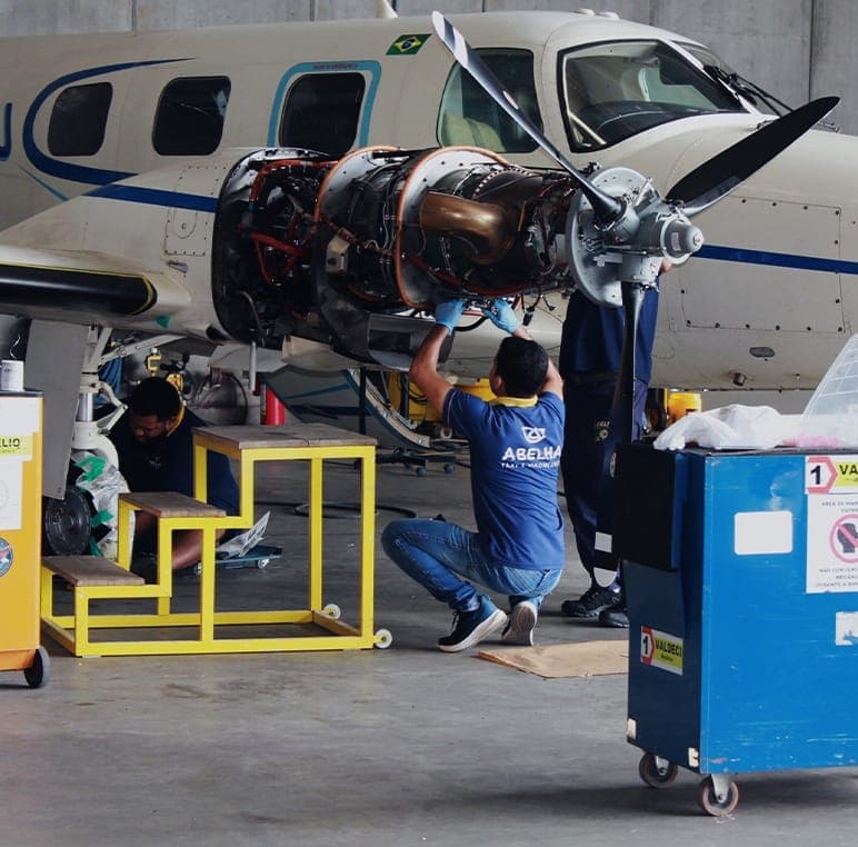 Mecânicos da Abelha trabalhando em uma aeronave dentro do hangar