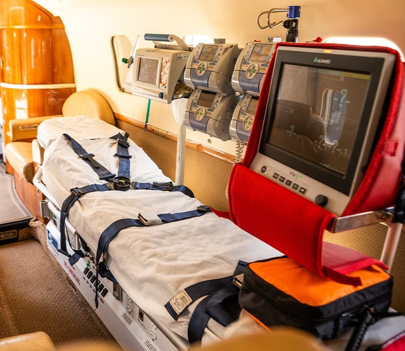 Interior da UTI aérea da Abelha, com maca, monitor multiparâmetros e bombas de infusão.